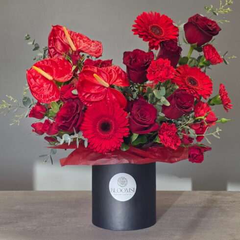 Luxury red flower box arrangement with roses, anthuriums, gerberas and eucalyptus by BLOOMSI florist in Canada